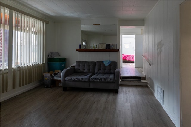 living room featuring dark hardwood / wood-style floors and wooden walls