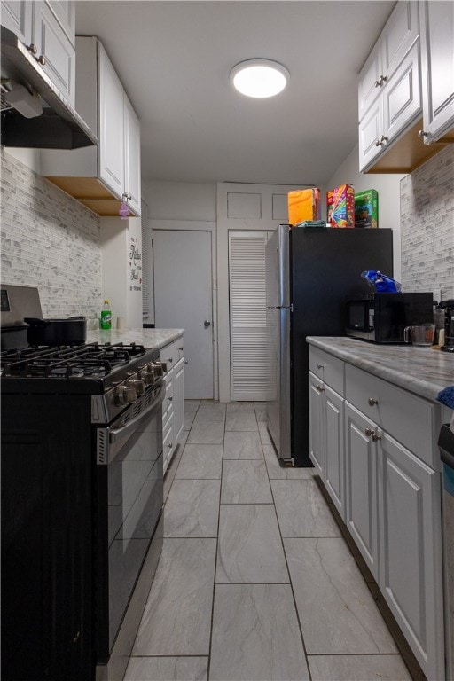 kitchen with white cabinets, backsplash, and appliances with stainless steel finishes