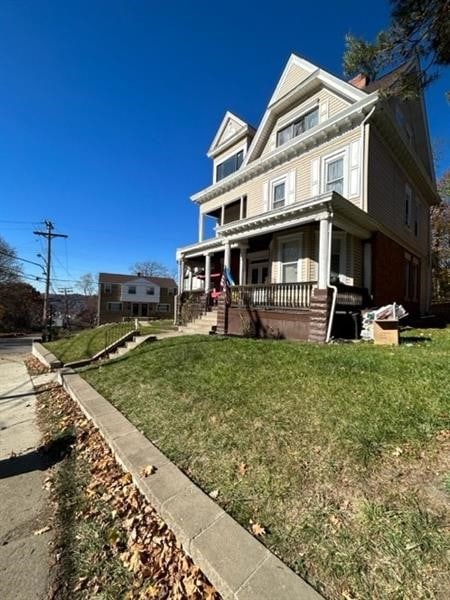 view of front facade featuring covered porch and a front lawn