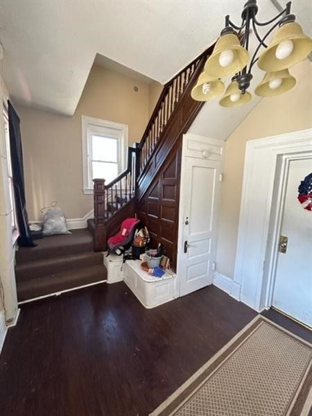 staircase featuring hardwood / wood-style flooring and a notable chandelier