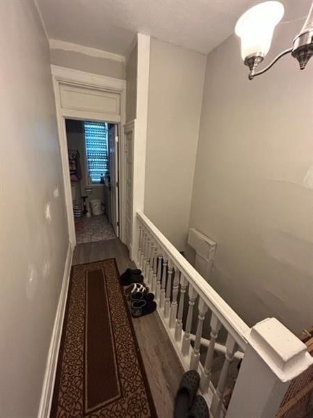 stairway featuring hardwood / wood-style flooring and a chandelier