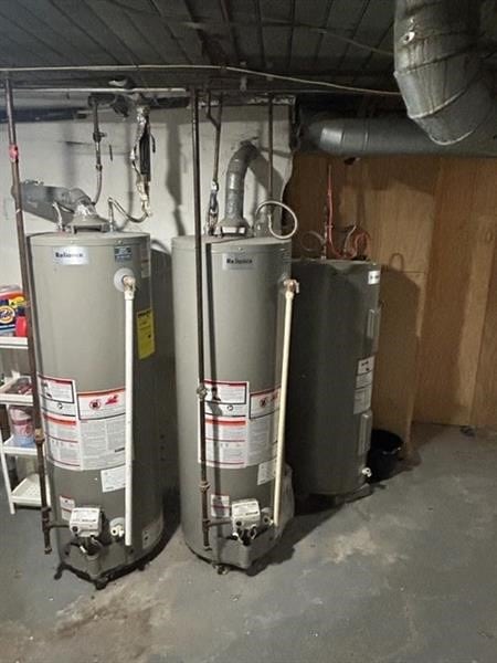 utility room featuring electric water heater and gas water heater