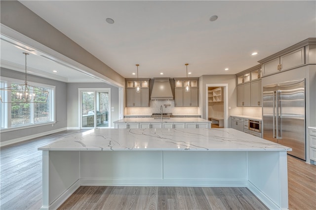 kitchen with a large island, sink, pendant lighting, and appliances with stainless steel finishes