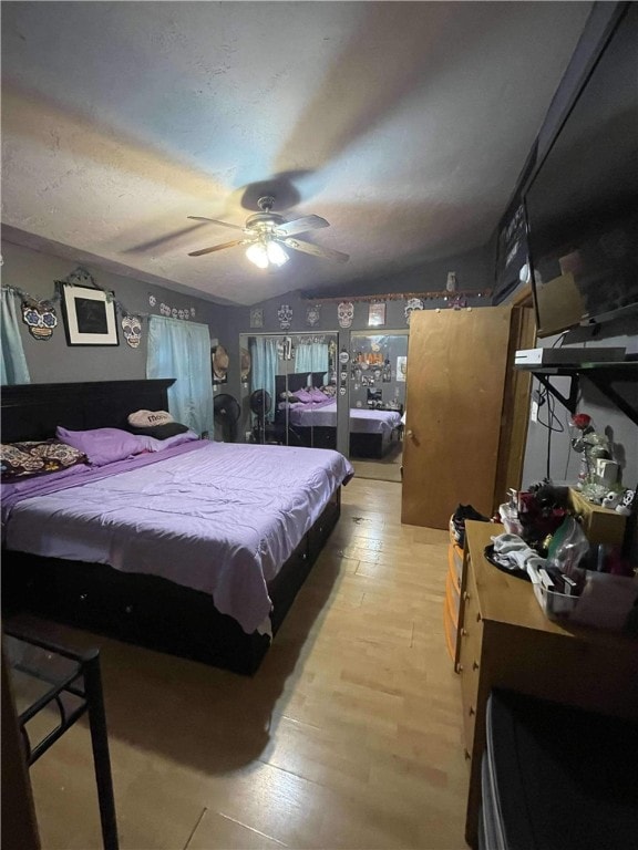 bedroom featuring ceiling fan, lofted ceiling, and light wood-type flooring