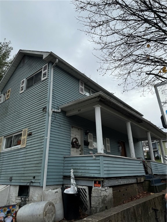 view of side of property featuring covered porch