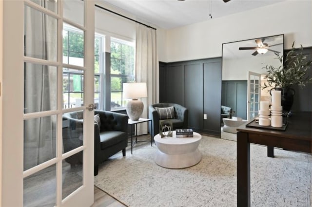 living area featuring french doors, hardwood / wood-style flooring, and ceiling fan