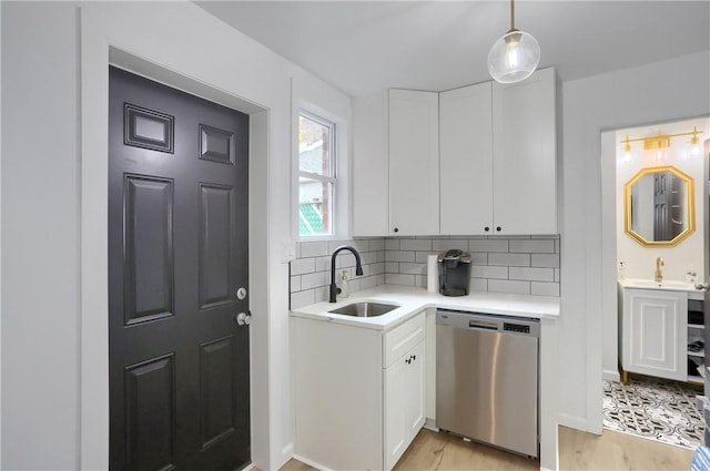 kitchen featuring dishwasher, decorative backsplash, white cabinets, and sink