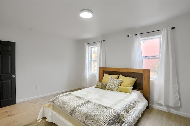 bedroom featuring multiple windows and light wood-type flooring