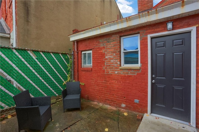 view of exterior entry with a patio area