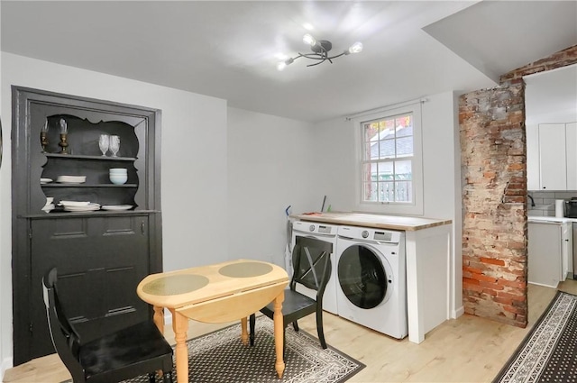 clothes washing area with light hardwood / wood-style floors and washer / clothes dryer