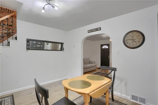 1402 Bingham St, South Side, PA 15203 - dining area featuring arched walkways, light wood-style floors, and baseboards