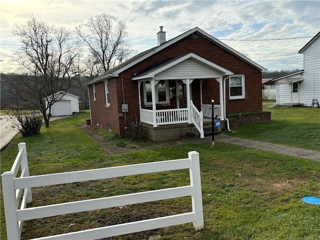 bungalow-style home with an outbuilding, a front lawn, and covered porch