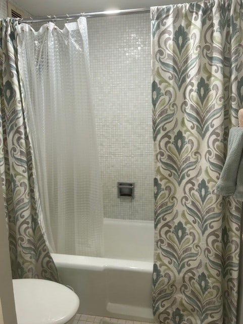 full bath featuring toilet, shower / tub combo, and tile patterned floors