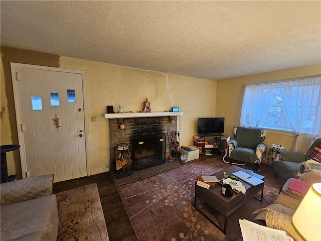 living room featuring a fireplace, a textured ceiling, and dark hardwood / wood-style floors