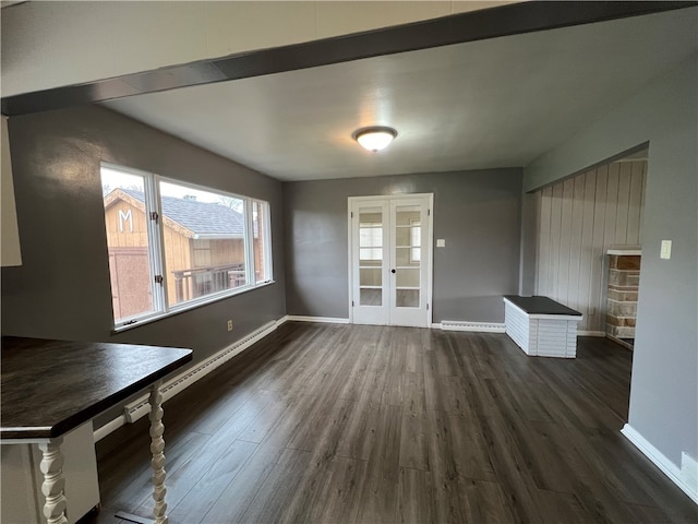 unfurnished dining area featuring dark hardwood / wood-style floors and a baseboard heating unit