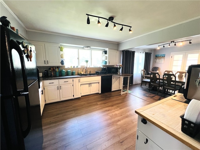 kitchen with white cabinets, hardwood / wood-style flooring, plenty of natural light, and black appliances