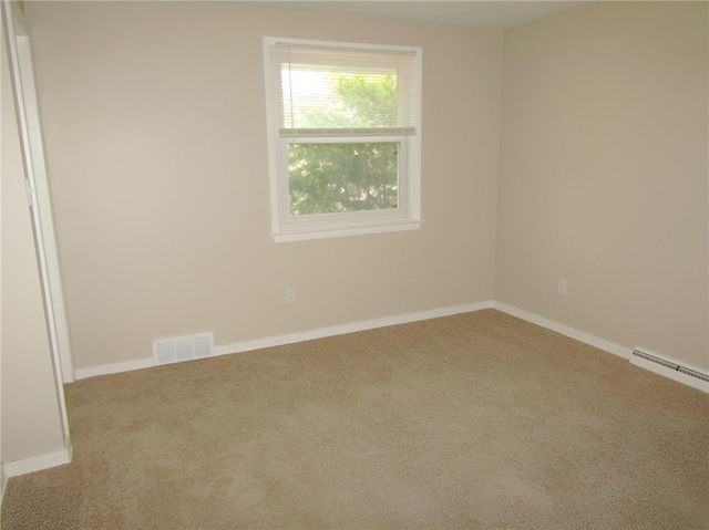 carpeted empty room featuring baseboard heating