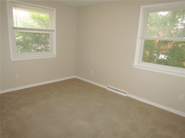 carpeted spare room with a baseboard radiator