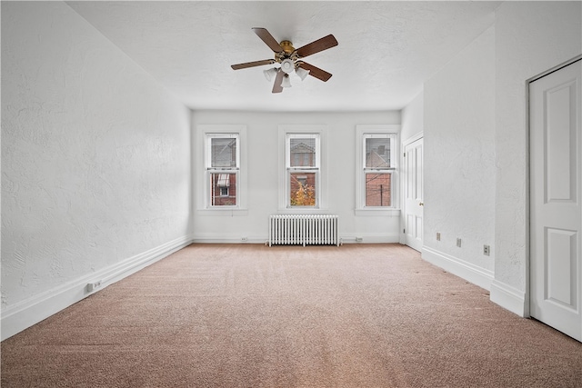 interior space featuring ceiling fan, radiator heating unit, and a textured ceiling