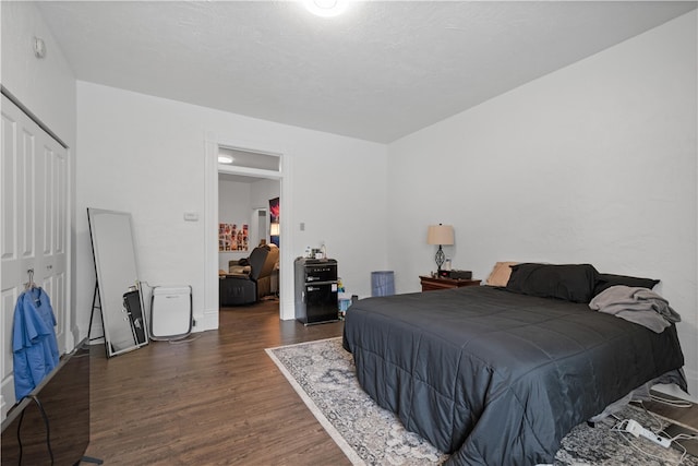 bedroom with a closet and dark wood-type flooring