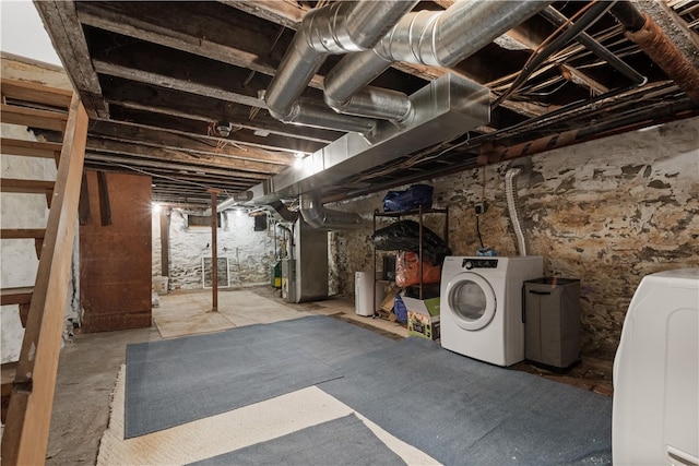 basement featuring washing machine and dryer and heating unit