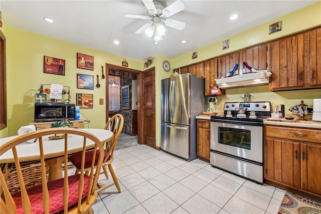 kitchen with ceiling fan, light tile patterned floors, stainless steel appliances, and ventilation hood