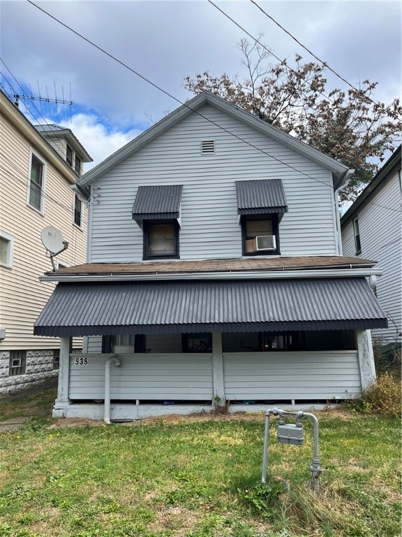 rear view of property with a lawn