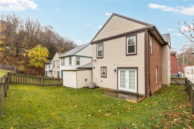 back of house featuring a lawn and central AC