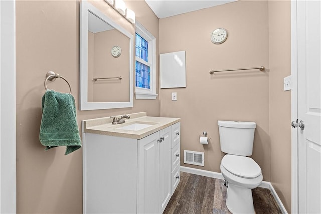 bathroom featuring wood-type flooring, vanity, and toilet