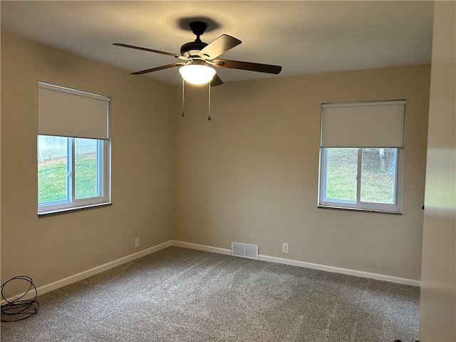 empty room featuring ceiling fan and carpet