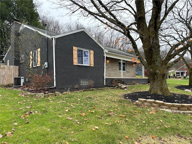 view of side of home with a yard and central air condition unit