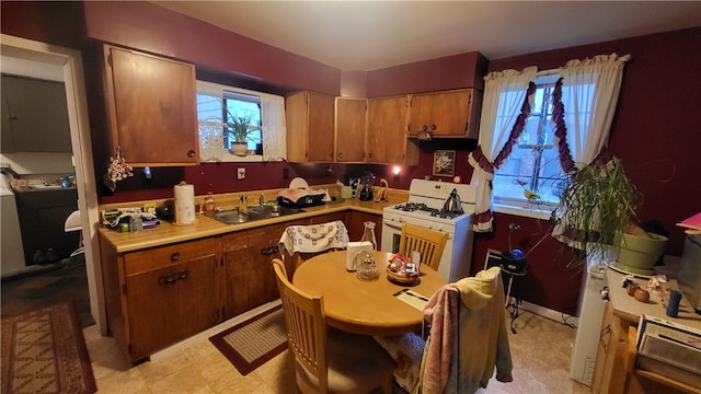 kitchen featuring white gas range oven and sink