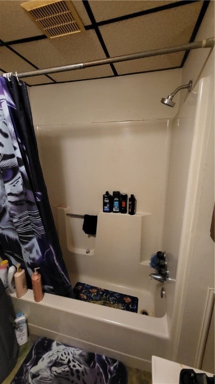 bathroom featuring shower / bath combo with shower curtain and a drop ceiling