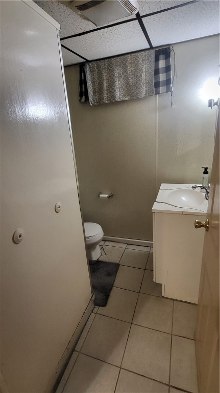 bathroom featuring tile patterned floors, a paneled ceiling, vanity, and toilet