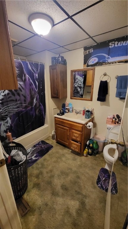 full bathroom featuring a paneled ceiling, shower / bath combination with curtain, toilet, and vanity