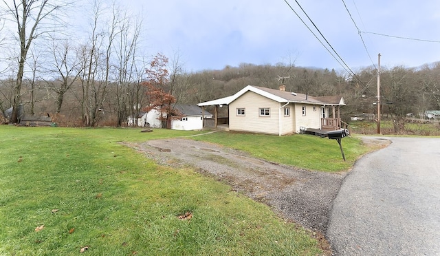 view of side of property featuring a yard and a wooden deck