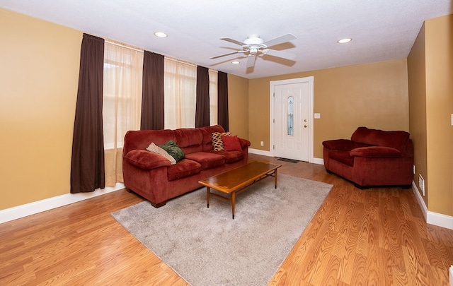 living room featuring ceiling fan and light hardwood / wood-style flooring