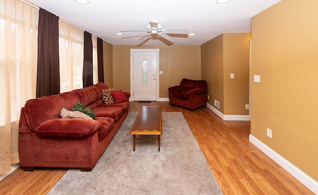 living room featuring ceiling fan and light hardwood / wood-style flooring