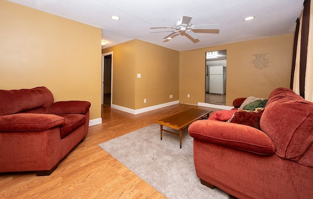 living room featuring ceiling fan and light hardwood / wood-style floors