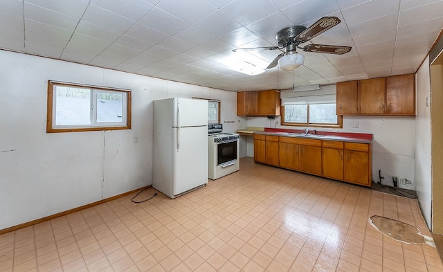 kitchen with white appliances, ceiling fan, and sink