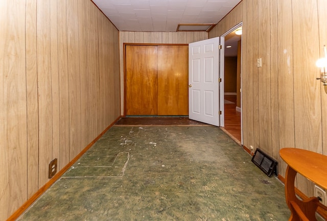 hallway featuring wooden walls