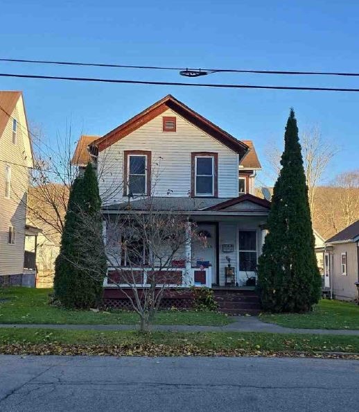 view of front of house with a porch and a front lawn