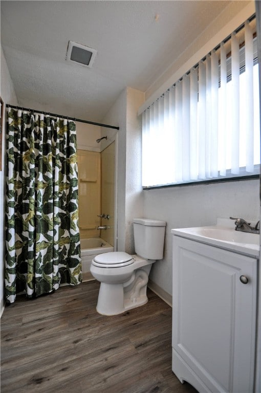 full bathroom with hardwood / wood-style floors, vanity, toilet, and shower / bathtub combination with curtain