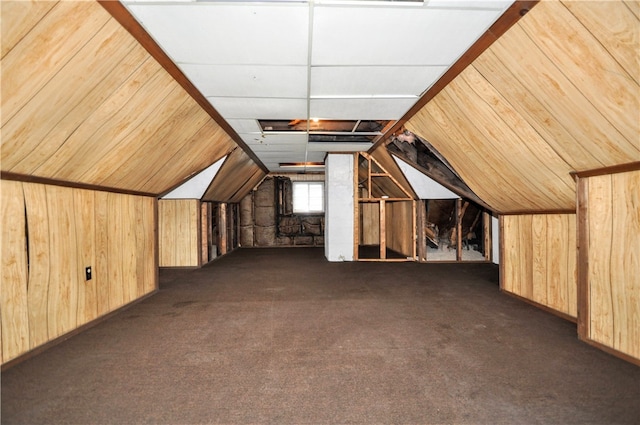 bonus room with dark colored carpet, wooden walls, and vaulted ceiling