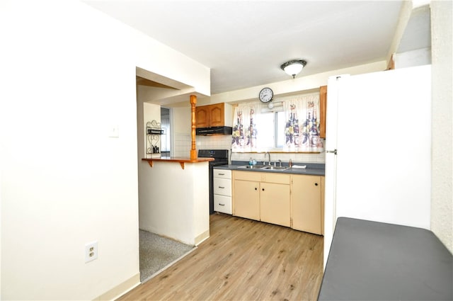 kitchen featuring decorative backsplash, light wood-type flooring, white refrigerator, and sink