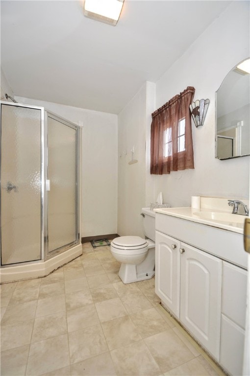 bathroom featuring tile patterned floors, vanity, toilet, and a shower with shower door