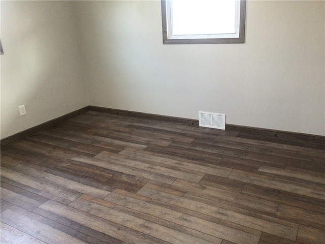 spare room featuring dark wood-type flooring