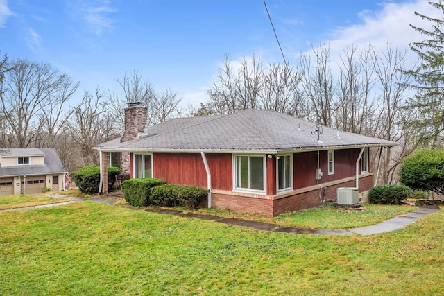 view of home's exterior featuring central AC unit and a lawn