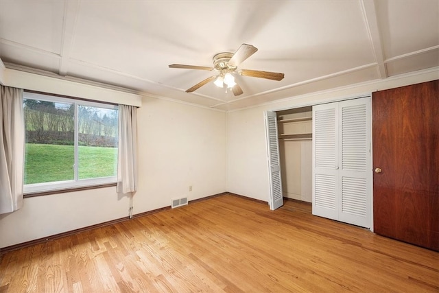 unfurnished bedroom with ceiling fan, a closet, and light wood-type flooring