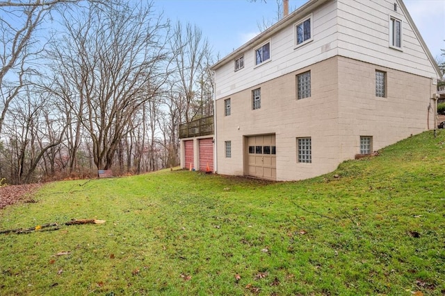 view of side of home featuring a yard, a deck, and a garage